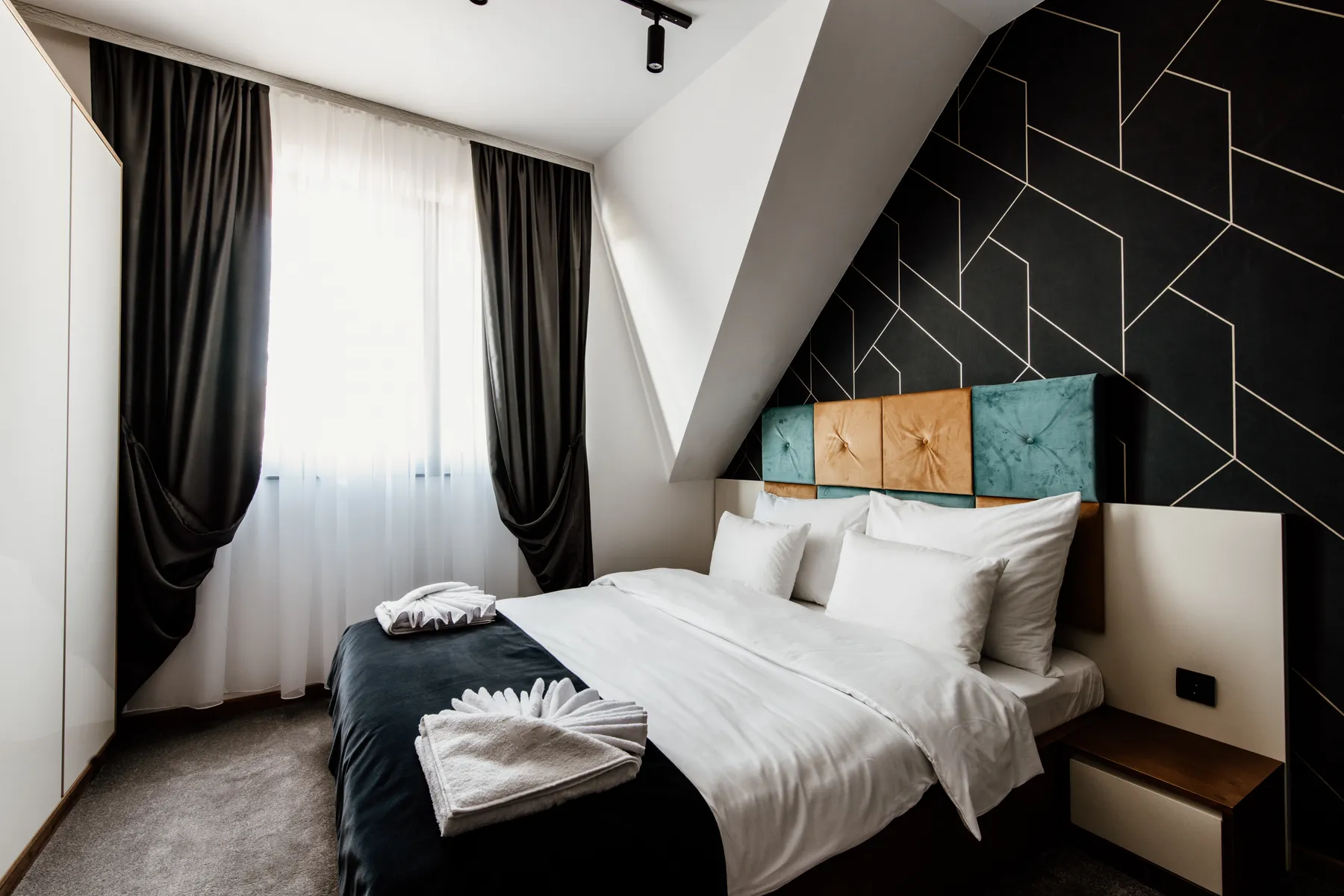 A neatly made bedroom in a bright, hotel-style interior